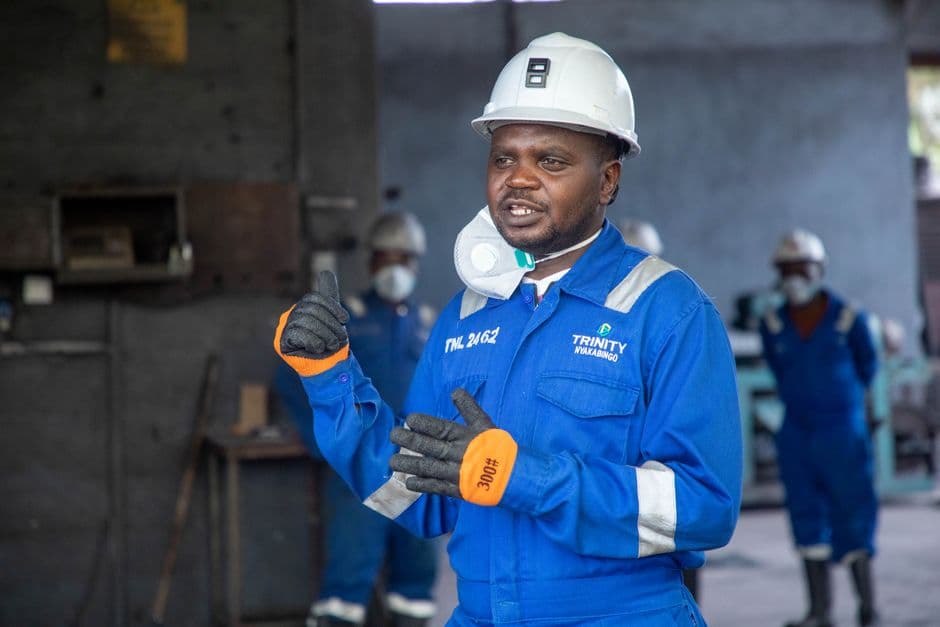 Engineer discussing safety procedures in an industrial factory setting, wearing full protective gear.
